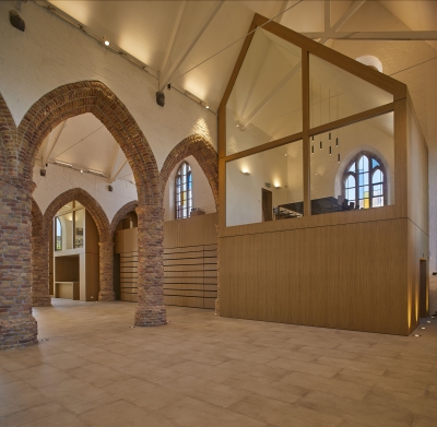In het westelijke deel van de kerk plaatsten de ontwerpers een modern volume met vergaderzalen, een bar en een moduleerbare tribune. (Foto: OE, Kris Vandevorst)